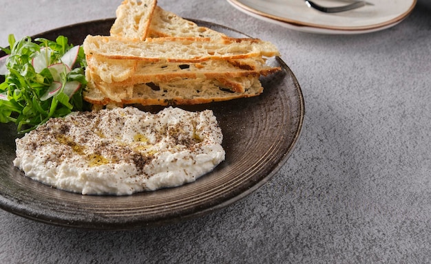 Stracciatella mozzarella de búfalo italiana servida com rúcula fresca e pão torrado