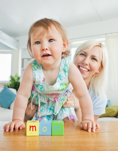 Strahlende Mutter, die mit ihrer Tochter spielt