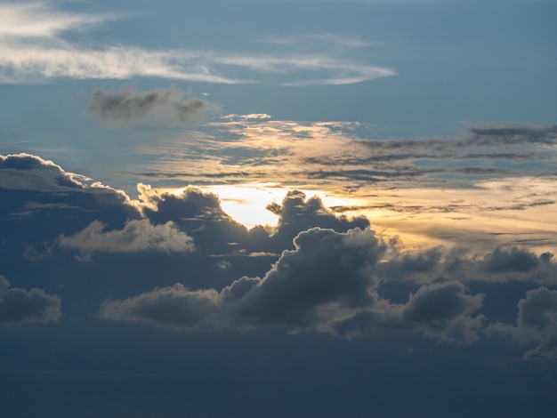 Strahlende Sonne am blauen Himmel mit dunklen Wolken