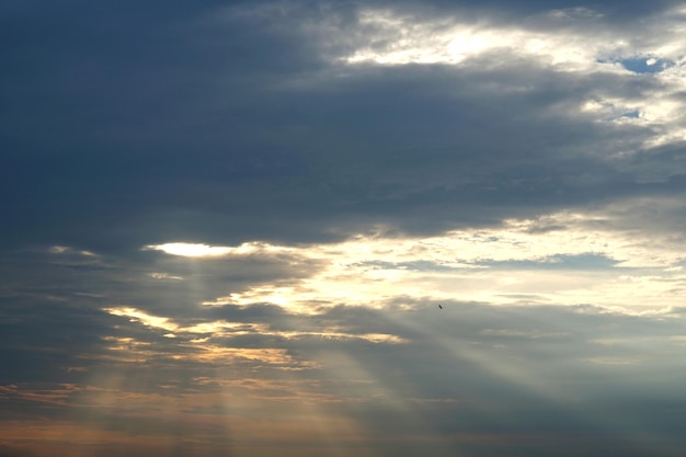 Strahlende Sonne hinter Nimbuswolken am Himmel