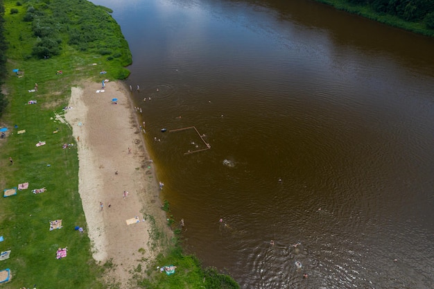 Strand am Ufer des Flusses mit Blick auf die Schwimmer von oben