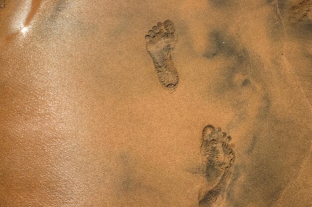 Strand des Roten Meeres Menschliche Fußabdrücke auf einem gelben Quietschen Ägypten Sommerurlaub und Outdoor-Abenteuerkonzept