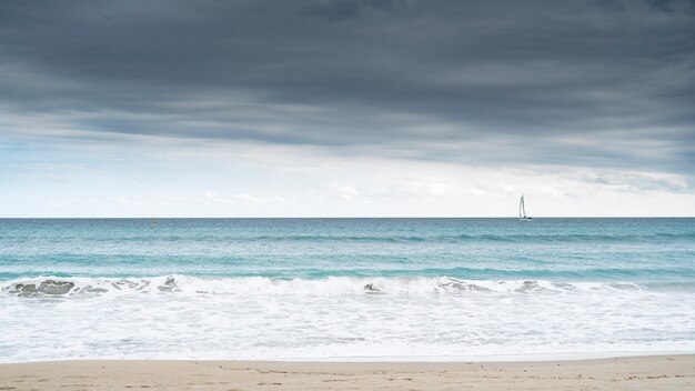 Strand mit einem Segelboot. Freiheitskonzept