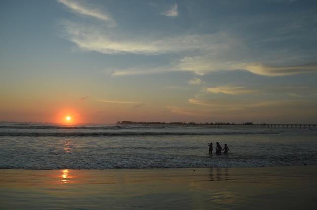 Strand mit Meer und Pier und Menschen