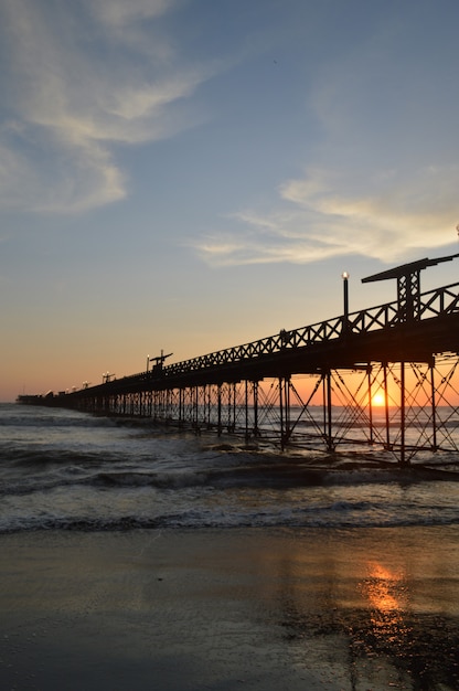 Strand mit Meer und Pier und Menschen