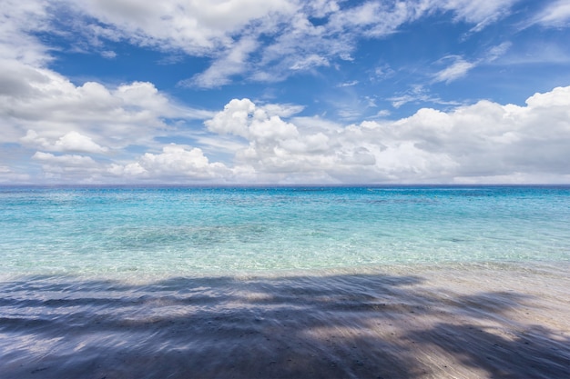 Strand mit türkisfarbenem Wasser und Wolken auf blauer Himmelslandschaft