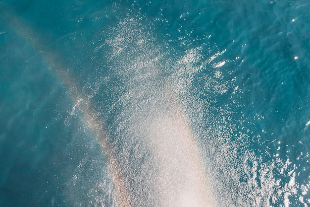 Strand, Reisen und Umwelt. Regenbogen auf blauem Ozeanhintergrund. Ozeanwasseroberflächenbeschaffenheit, Weinlesesommerhintergrund.