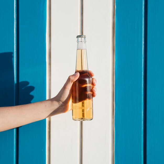 Strand- und Sommerkonzept mit der Hand, die Bier hält