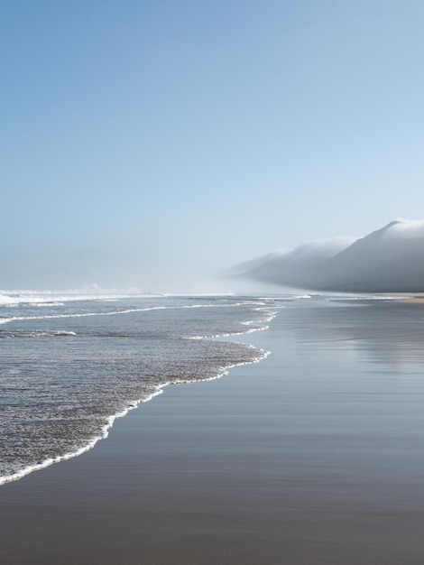 Strand von Cofete auf Fuerteventura Unberührter Strand unter der nebligen Berglandschaft