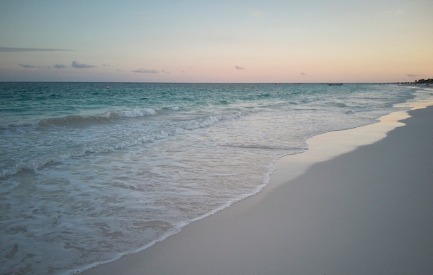 Strand von Xpu-Ha bei Sonnenuntergang: Stellen Sie sich vor, wo das transparente Meer mit dem weißen Strand verschmilzt, der von den warmen Tönen des schwachen Lichts bei Sonnenuntergang gefärbt wird.