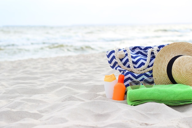 Strandaccessoires und Sonnencreme auf dem Sand des Meeres