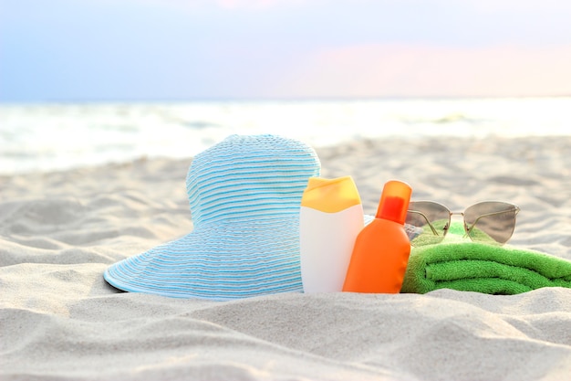 Strandaccessoires und Sonnenschutzmittel auf dem Sand des Meeres
