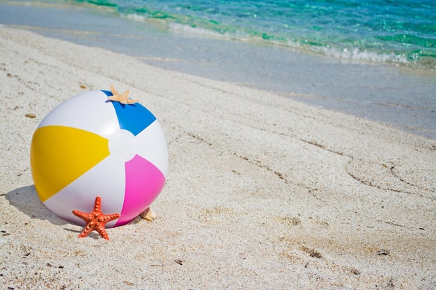 Strandball mit Seesternen am Ufer