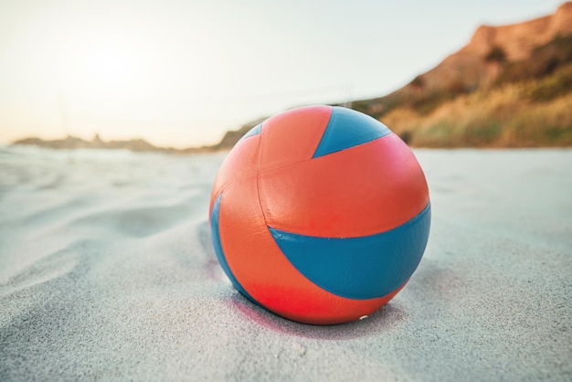 Strandball und Volleyball auf Sand ein Spiel bei Sonnenuntergang am tropischen Ozean Ziel Fitness-Spaß und Sommersport am Meer am Abend Weiße Sandküste ein Volleyball und eine leere Meereslandschaft