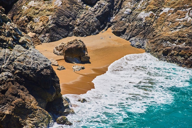 Strandbucht am Meer mit Sandstrand, umgeben von Felsen