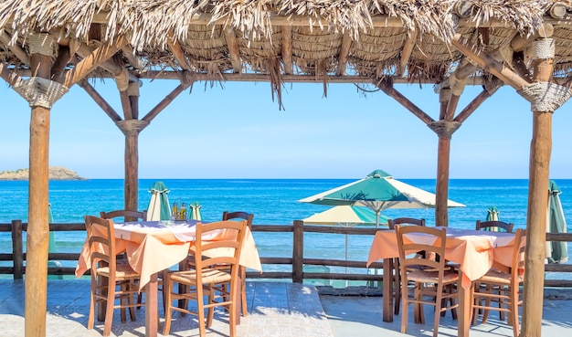 Strandcafe mit Holztischen und Stühlen am Meer