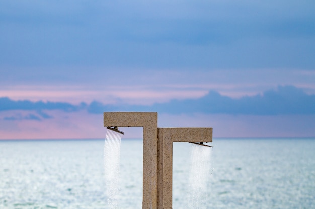 Stranddusche auf dem Ufer gegen das Meer und den blauen Himmel in Batumi