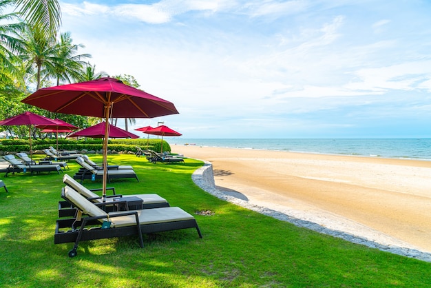 Strandkorb und Sonnenschirm mit Ozeanmeerstrandhintergrund