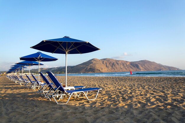 Strandliegen unter Sonnenschirmen am Meer