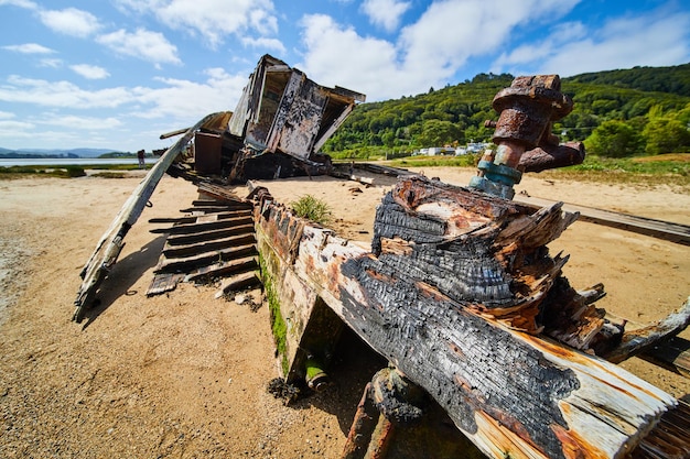 Strandschiffswrack, das nach Brand am Strand auseinanderfällt