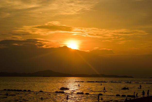 Strandsonnenuntergang mit den Schattenbildleuten sandig