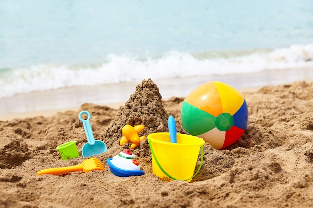 Strandspielzeug für Kinder - Eimer, Spaten und Schaufel auf Sand an einem sonnigen Tag