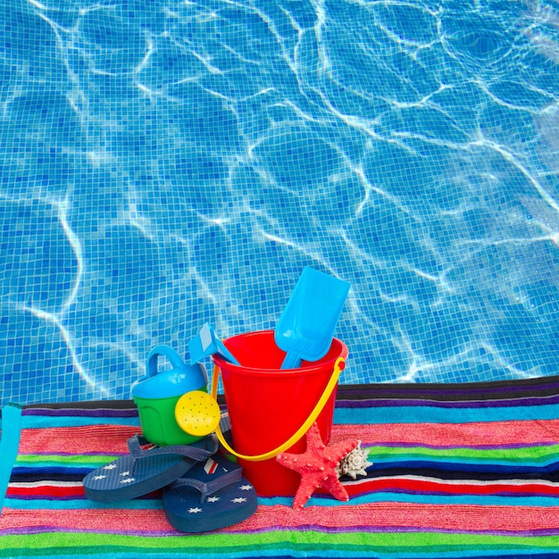 Strandspielzeug mit Flip-Flops und Seestern auf Handtuch to