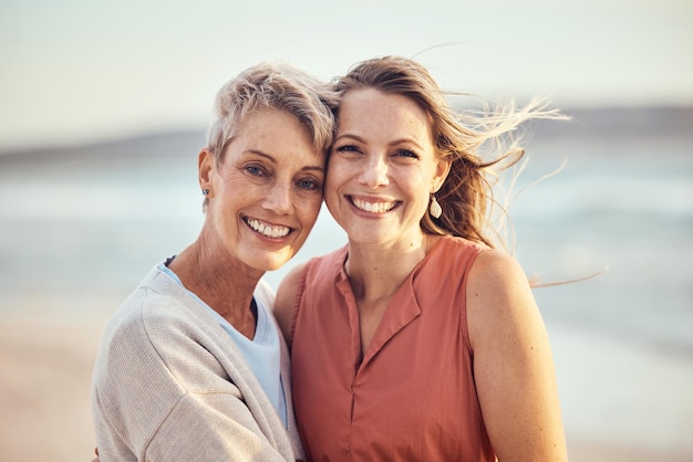 Strandumarmung und ältere Mutter und Tochter entspannen sich und genießen Zeit Freiheit Frieden oder Reiseurlaub Mamas lieben die Natur, Wind und ein glückliches Familienporträt von Frauen im Urlaub in Toronto, Kanada