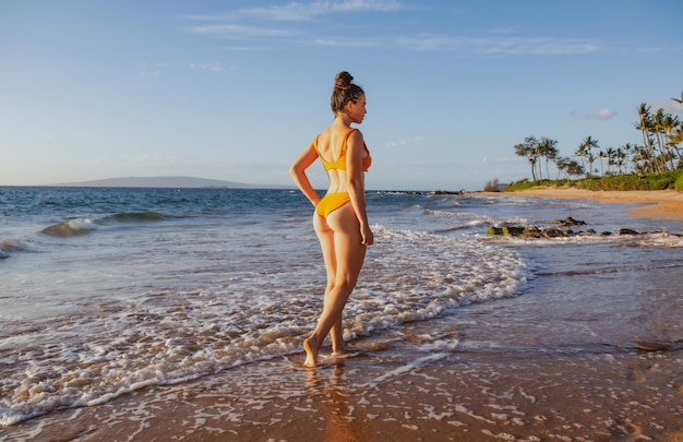 Strandurlaub, schöne Frau im Bikini, die am Sommertag Hawaii den Blick auf das Meer am Strand genießt