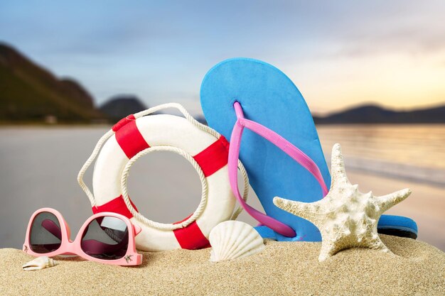 Strandzubehör auf Sand. Flip Flops, Sonnenbrille, Seestern