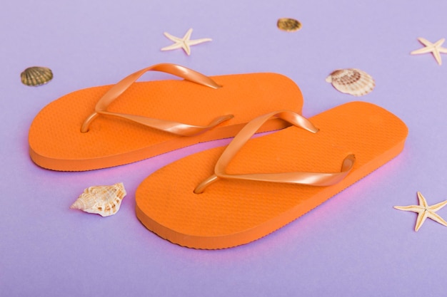 Strandzubehör Flip Flops und Seesterne auf farbigem Hintergrund Draufsicht Mock up mit Kopierbereich