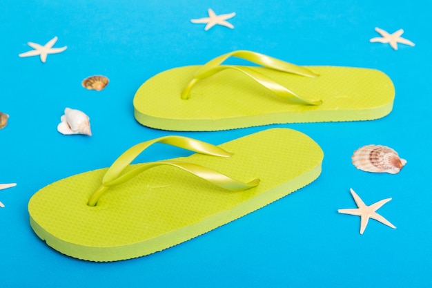 Strandzubehör Flip Flops und Seesterne auf farbigem Hintergrund Draufsicht Mock up mit Kopierbereich