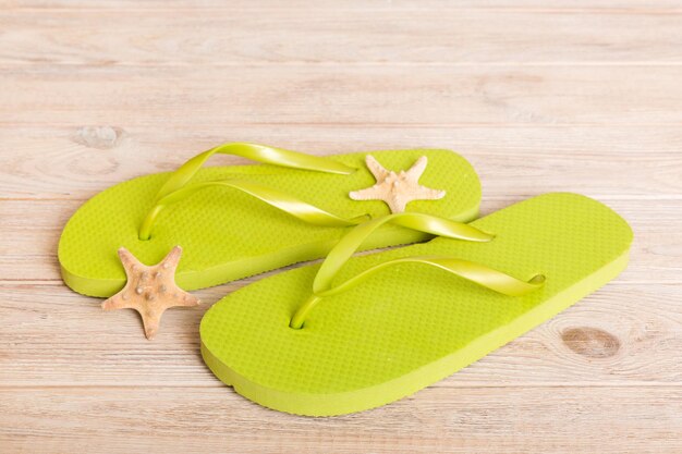 Strandzubehör Flip Flops und Seesterne auf farbigem Hintergrund Draufsicht Mock up mit Kopierbereich