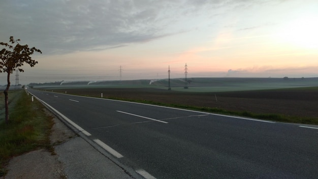 Foto straße durch landschaft gegen den himmel beim sonnenuntergang