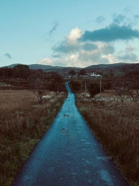 Foto straße inmitten des feldes gegen den himmel