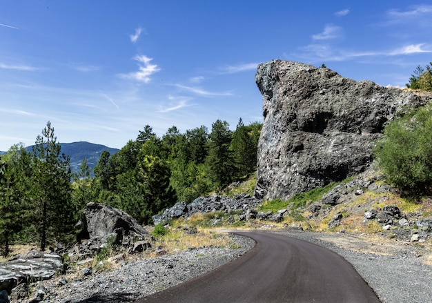 Foto straße inmitten von felsen und bäumen gegen den himmel