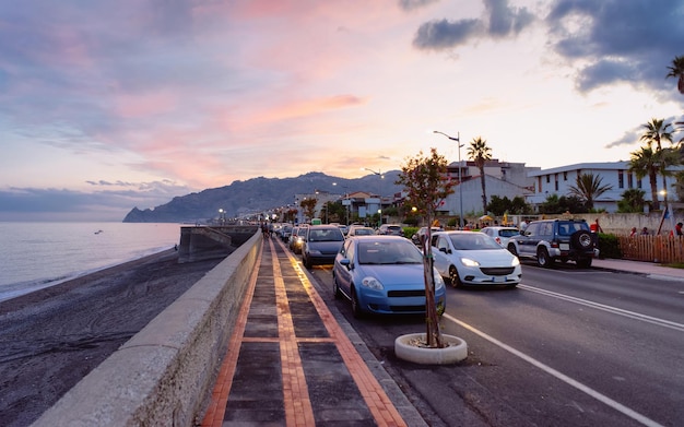 Straße mit Autos am Strand im Mittelmeer in Santa Teresa di Riva, Messina auf der Insel Silicy in Italien