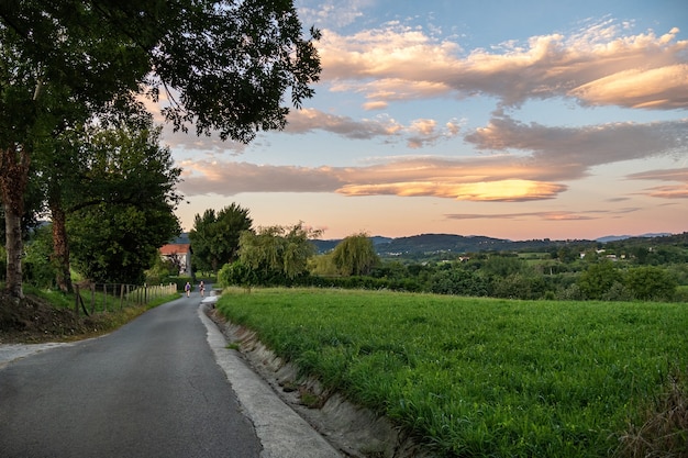 Straße mit Reisenden in der Landschaft erstaunliche bunte Wolken über dem Feld irun Baskenland Spanien