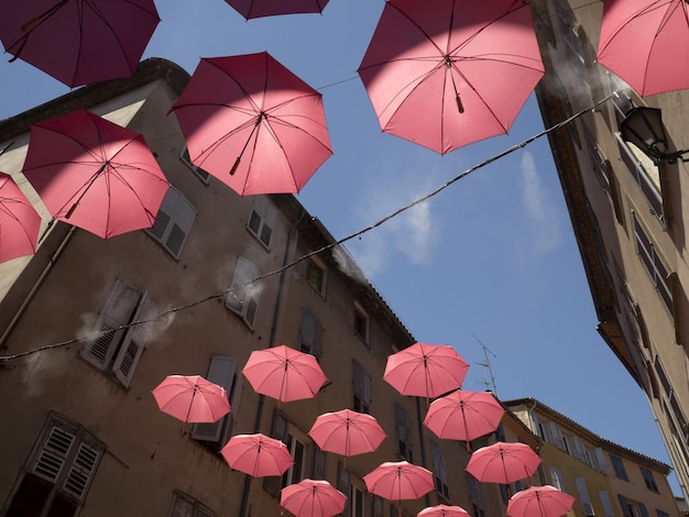 Straße mit rosa Regenschirmen in Grasse, Frankreich