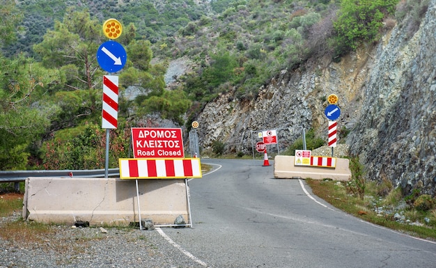 Straße unter Reparaturen im Troodos-Gebirge, Zypern. Stopp- und Straßensperrungsschilder in Englisch und Griechisch