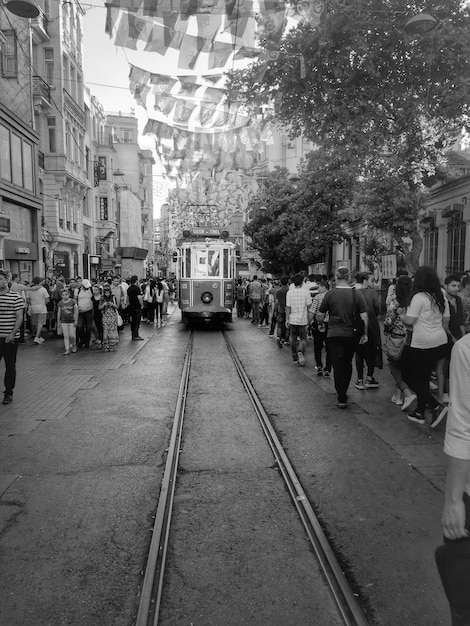 Straßenbahn auf einer Stadtstraße inmitten von Menschen