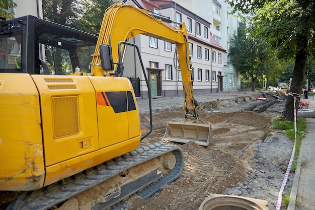 Straßenbau-Grabmaschine auf einer Baustelle, die eine Straße in der Stadt repariert