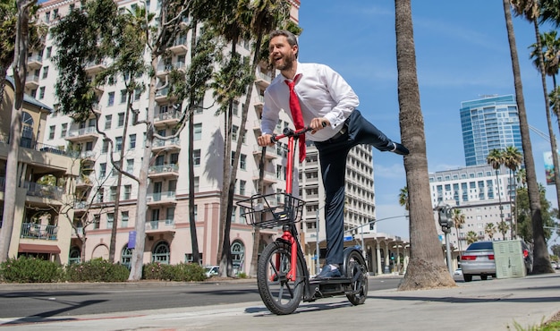 Straßenerholung Glücklicher Arbeitgeber reitet Escooter auf Bürgersteig Escooting für Erholung und Spaß