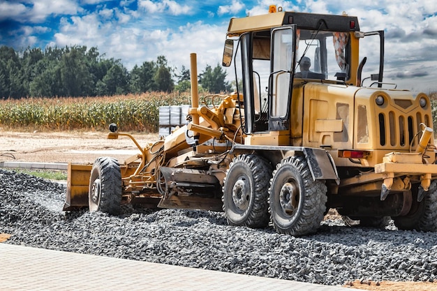 Straßengrader auf der Baustelle Leistungsstarke Baumaschine für Bodenausgleich und Aushub Nahaufnahme Professionelle Baumaschinen