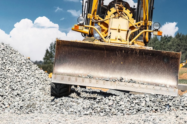 Straßengrader auf der Baustelle Leistungsstarke Baumaschine für Bodenausgleich und Aushub Nahaufnahme Professionelle Baumaschinen