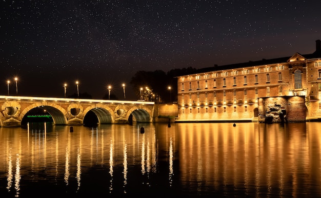 Straßenlaternen spiegeln sich im Fluss Garonna und in der Brücke Pont Neuf in Toulouse, Frankreich