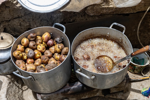 Foto straßenmahlzeit in peru kartoffeln im topf draußen kochen