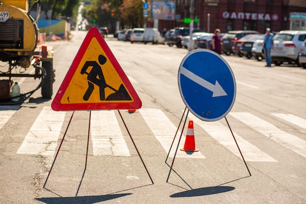 Straßenreparatur. Warnschilder über Reparaturarbeiten an einem Pflaster. Aufmerksamkeitsumweg