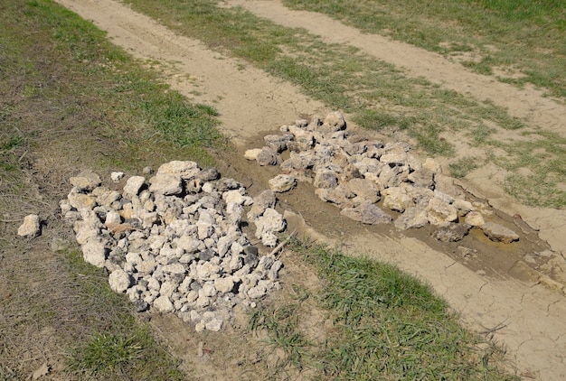 Straßenreparaturgruben auf der Straße sind mit Steinen bedeckt