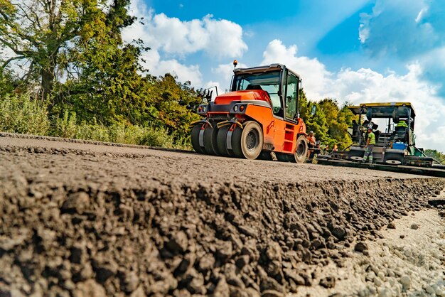 Straßenreparaturverdichter legt Asphalt Schwere Spezialmaschinen Asphaltfertiger in Betrieb Seitenansicht Nahaufnahme